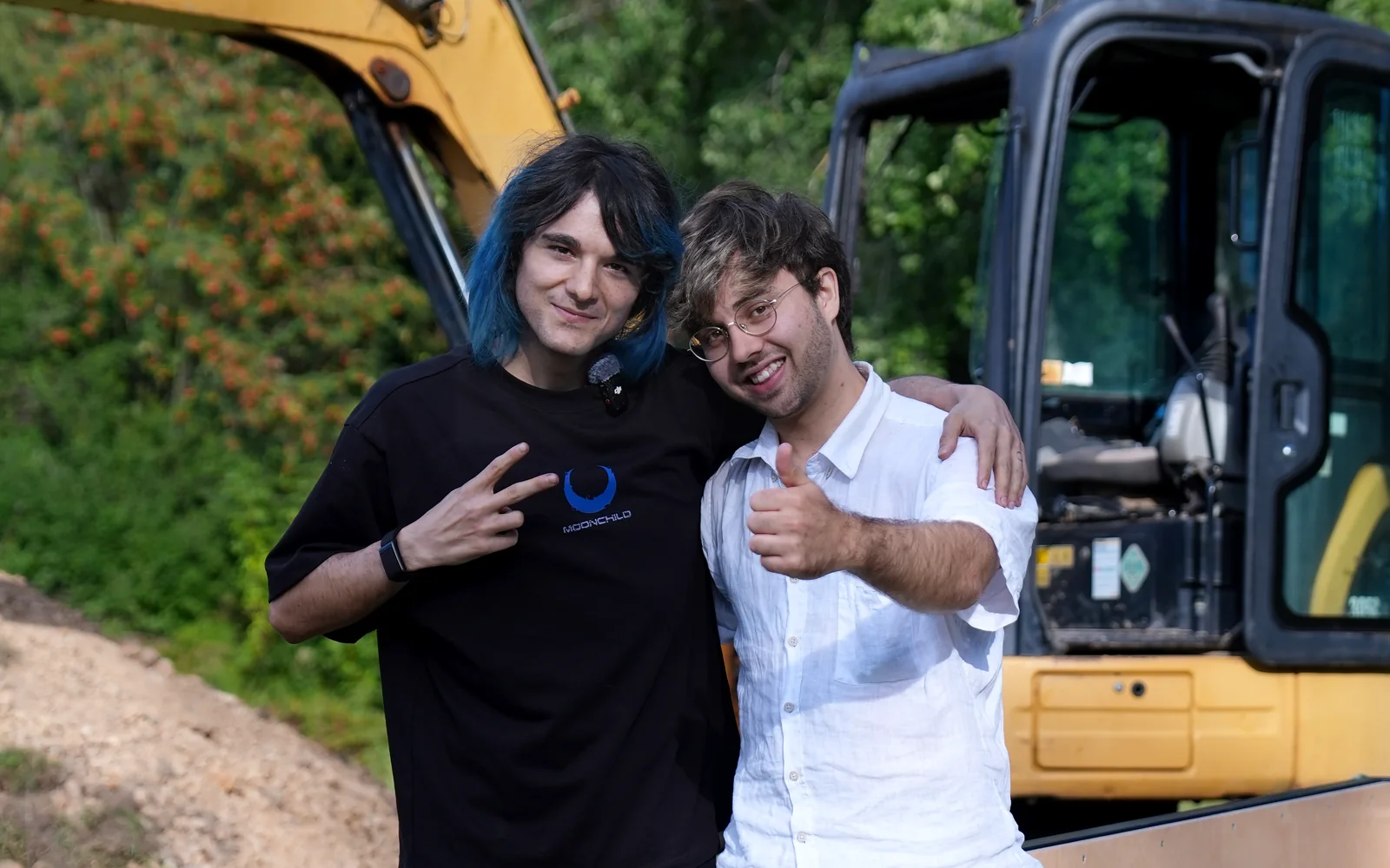 Kyo and Elias on location beside an excavator